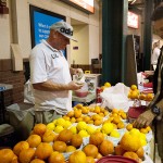 Jeremy Doucette from Visalia sells fruit while Beto Avila from Reedly CA, looks at the fresh fruit at the farmer's market held Friday night.